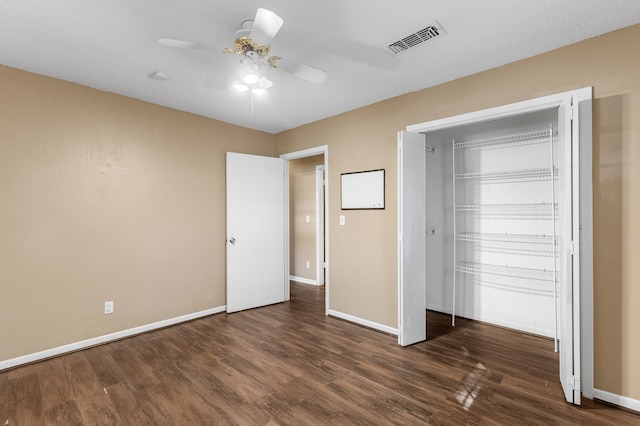 unfurnished bedroom featuring dark wood-type flooring and ceiling fan