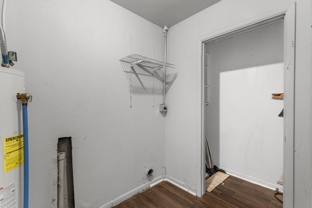 washroom featuring hookup for an electric dryer, dark hardwood / wood-style flooring, and gas water heater