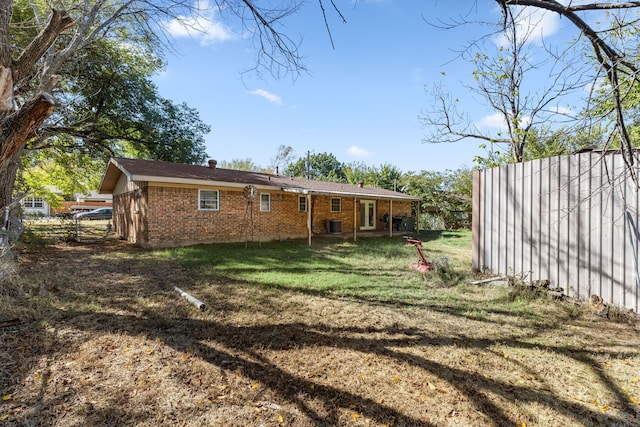 rear view of property featuring a lawn