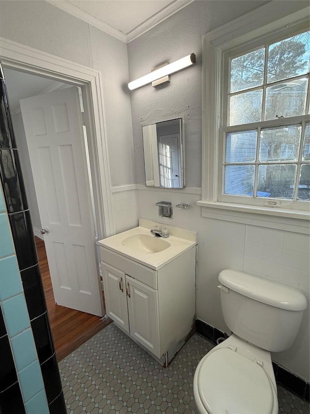 bathroom with toilet, tile patterned flooring, vanity, and ornamental molding