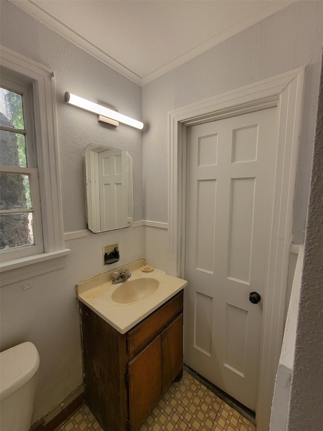 bathroom with vanity, toilet, and crown molding