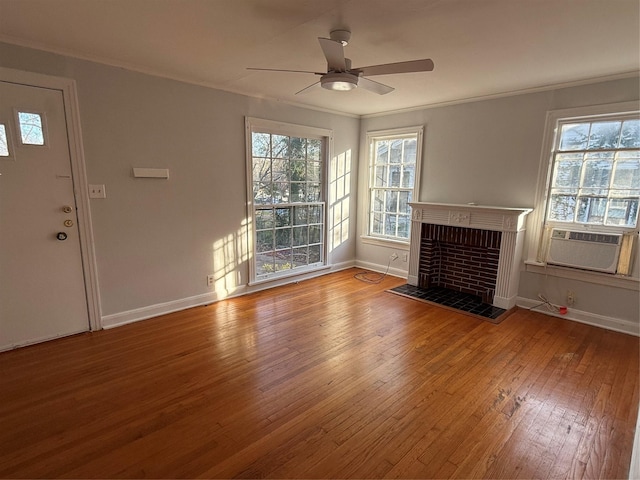 unfurnished living room featuring ceiling fan, a healthy amount of sunlight, a brick fireplace, cooling unit, and hardwood / wood-style flooring