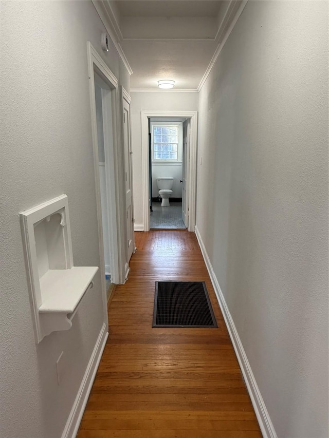 hall featuring ornamental molding and hardwood / wood-style flooring