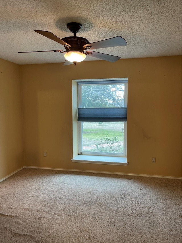 carpeted spare room with a textured ceiling and ceiling fan