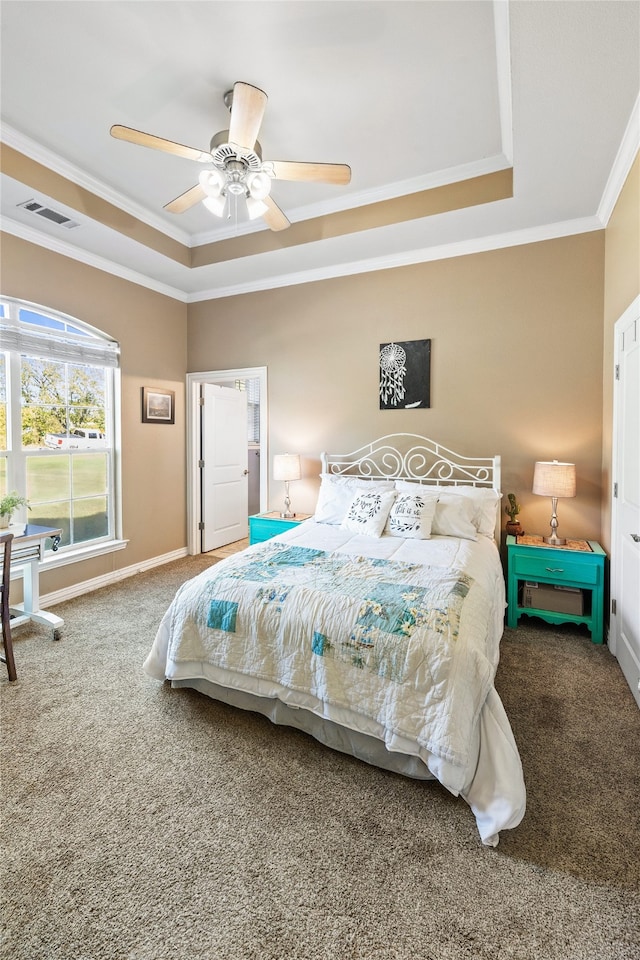 carpeted bedroom with ceiling fan, a raised ceiling, and crown molding