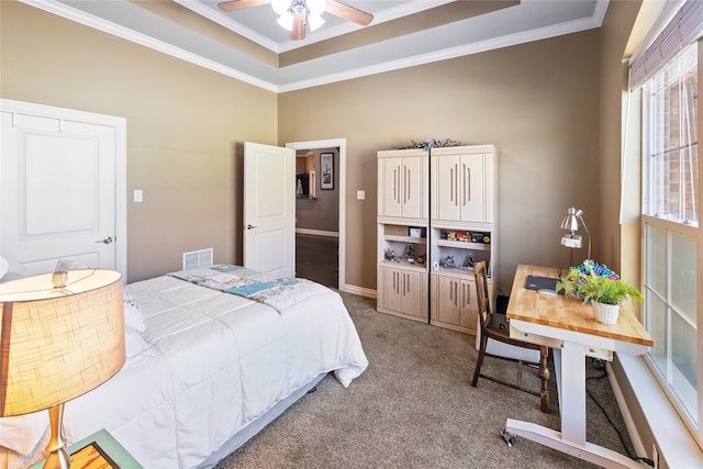 carpeted bedroom with a raised ceiling, ceiling fan, and ornamental molding