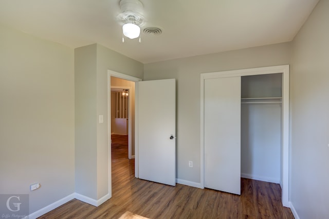 unfurnished bedroom featuring hardwood / wood-style flooring, a closet, and ceiling fan