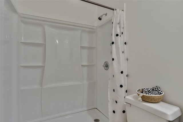 bathroom featuring a shower with curtain and toilet