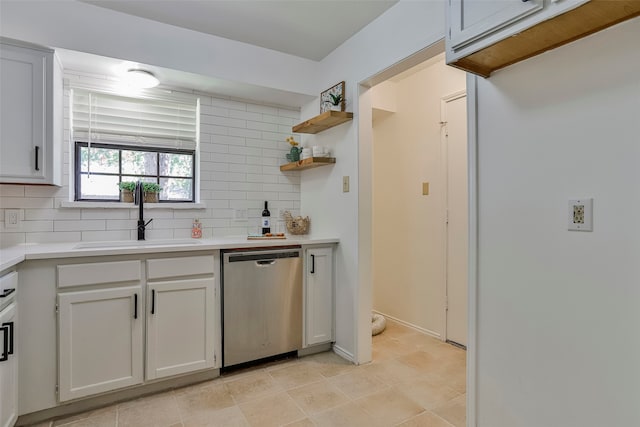 kitchen with backsplash, sink, dishwasher, white cabinetry, and light tile patterned flooring