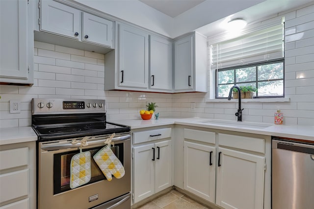 kitchen with appliances with stainless steel finishes, backsplash, white cabinetry, and sink