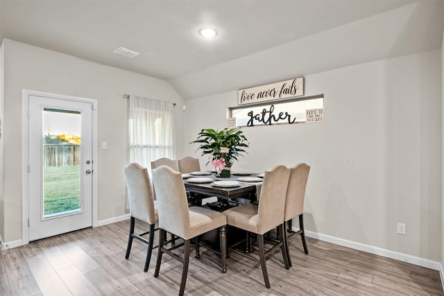 dining space featuring hardwood / wood-style flooring and vaulted ceiling