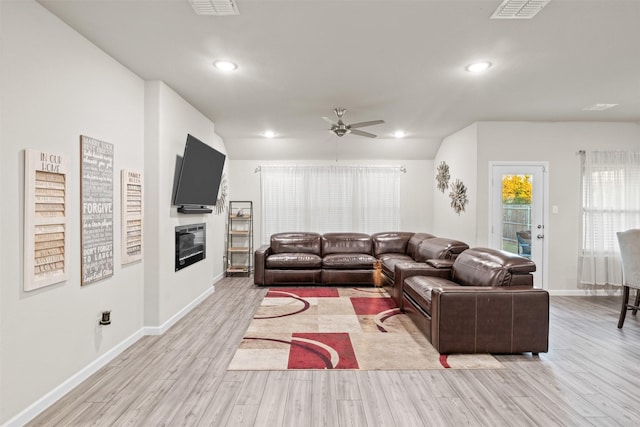 living room with ceiling fan and light hardwood / wood-style flooring