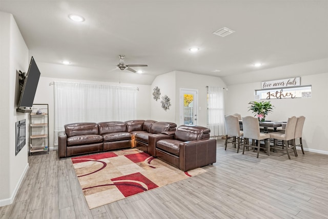 living room featuring light wood-type flooring, vaulted ceiling, and ceiling fan