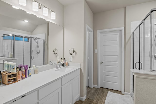 bathroom with vanity, an enclosed shower, lofted ceiling, and hardwood / wood-style flooring