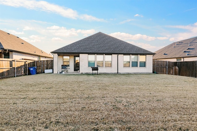 back of property with a lawn and a patio