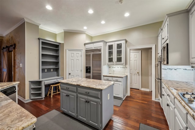 kitchen featuring appliances with stainless steel finishes, dark wood-type flooring, tasteful backsplash, and a center island