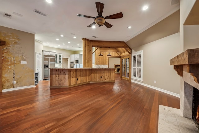 unfurnished living room with ceiling fan, wood-type flooring, a fireplace, and ornamental molding