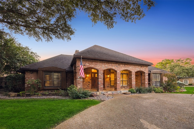 view of front of house featuring a lawn and covered porch