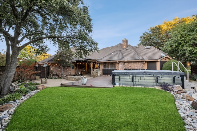 rear view of property featuring a yard, a pool, and exterior kitchen