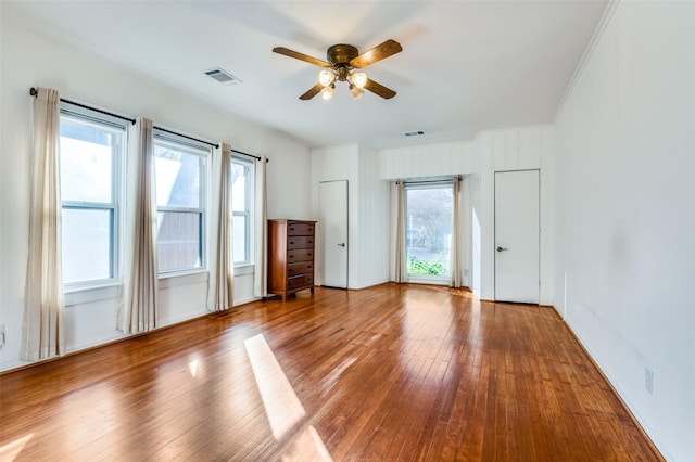 spare room featuring wood-type flooring, plenty of natural light, and ceiling fan