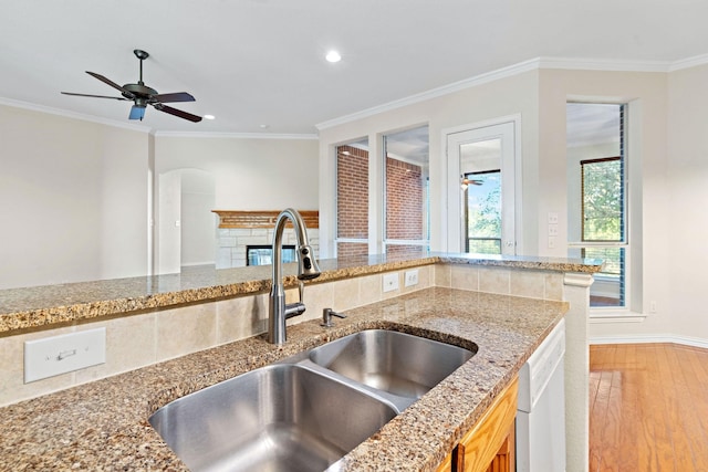 kitchen featuring white dishwasher, sink, light hardwood / wood-style floors, and crown molding