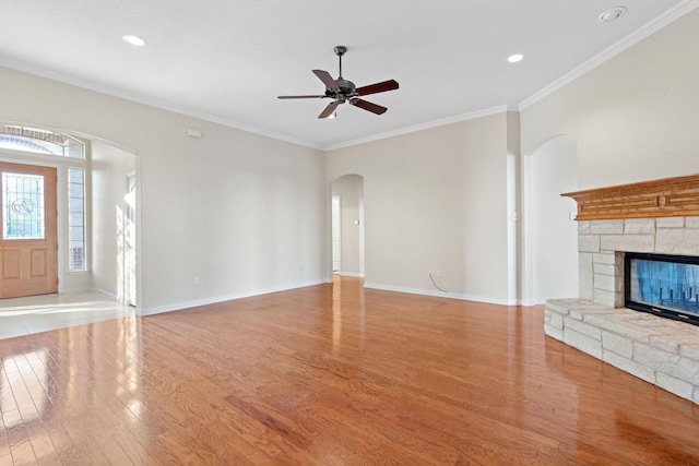 unfurnished living room with a fireplace, light hardwood / wood-style flooring, ceiling fan, and crown molding