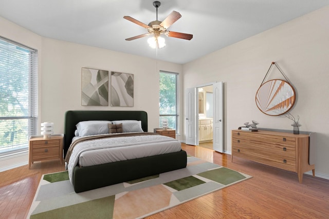 bedroom featuring wood-type flooring, ceiling fan, and connected bathroom