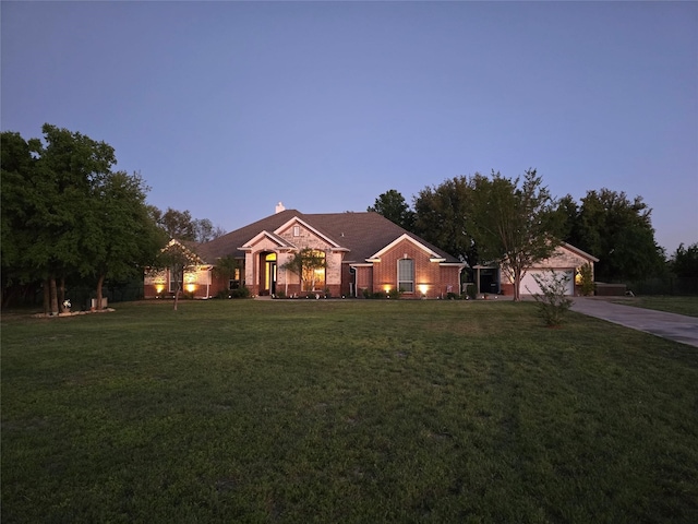 single story home featuring a garage and a yard