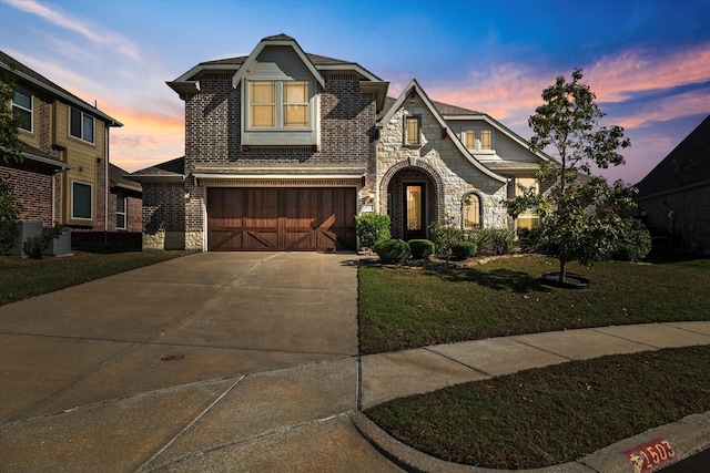 view of front of home with a yard and a garage