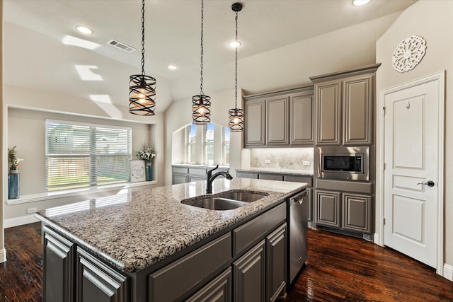 kitchen featuring appliances with stainless steel finishes, an island with sink, a wealth of natural light, and sink