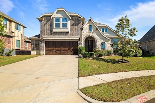 view of front of home with central air condition unit, a front yard, and a garage