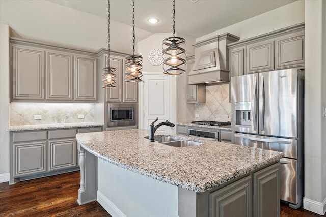 kitchen featuring premium range hood, sink, a center island with sink, appliances with stainless steel finishes, and lofted ceiling