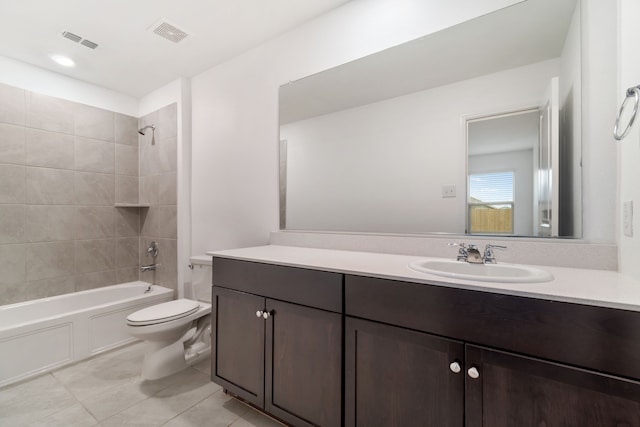 full bathroom featuring toilet, vanity, tiled shower / bath, and tile patterned flooring