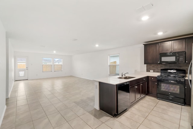 kitchen with black appliances, kitchen peninsula, sink, and light tile patterned flooring