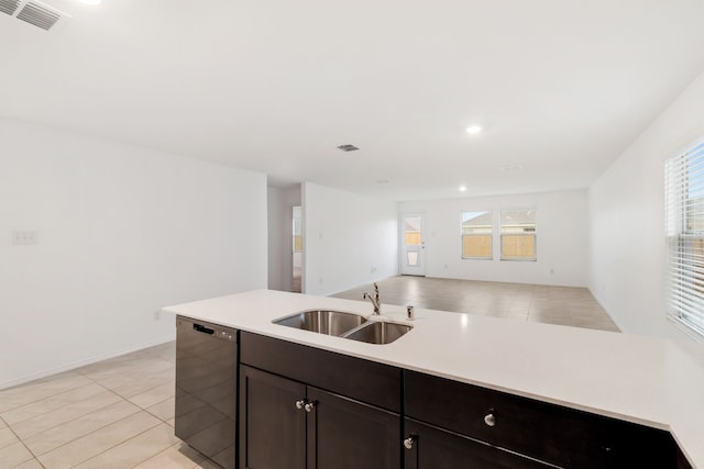 kitchen featuring light tile patterned floors, dark brown cabinets, sink, and dishwasher