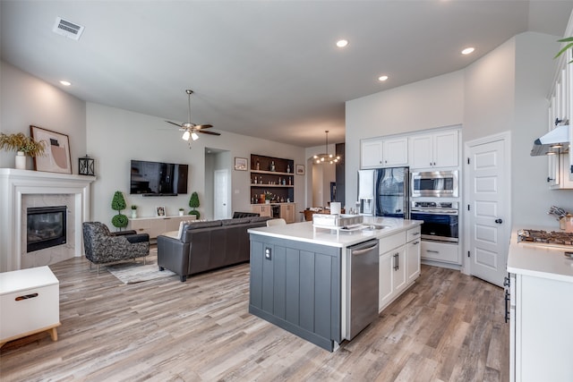 kitchen with white cabinetry, built in features, a kitchen island with sink, and stainless steel appliances