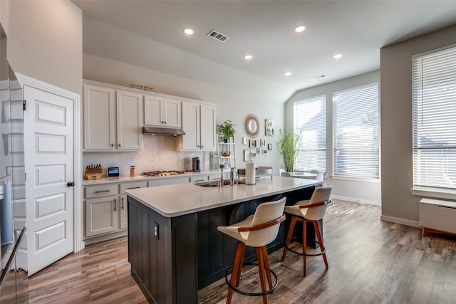 kitchen featuring sink, white cabinetry, an island with sink, lofted ceiling, and stainless steel gas cooktop