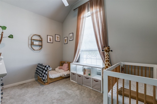 carpeted bedroom with vaulted ceiling, a crib, and multiple windows