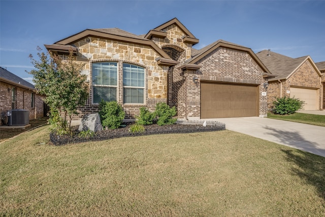 view of front of home featuring cooling unit, a garage, and a front lawn