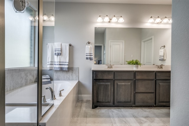 bathroom featuring tile patterned flooring, vanity, and tiled tub