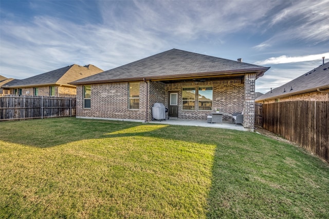 rear view of property with a lawn and a patio area