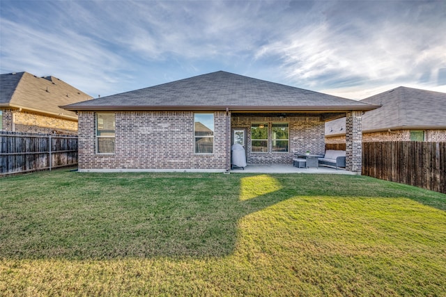 rear view of property featuring a patio and a lawn