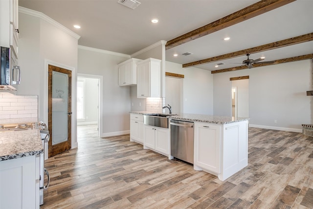 kitchen with light stone countertops, white cabinetry, and stainless steel appliances