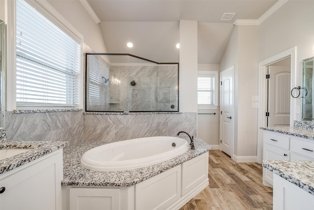 bathroom featuring ornamental molding, vanity, separate shower and tub, wood-type flooring, and lofted ceiling