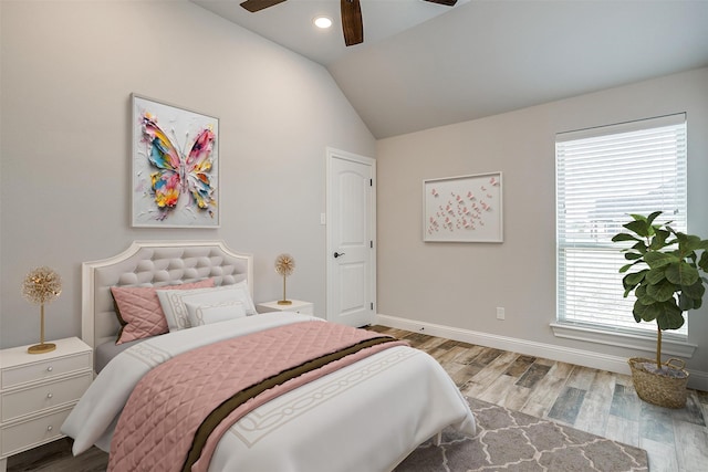 bedroom featuring ceiling fan, light hardwood / wood-style flooring, and lofted ceiling