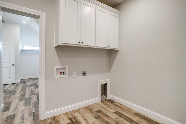 clothes washing area featuring cabinets, washer hookup, light hardwood / wood-style floors, and electric dryer hookup