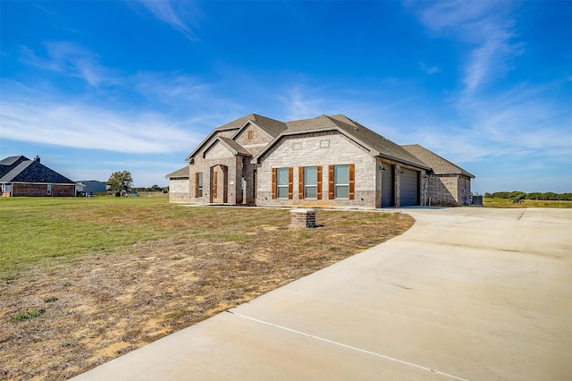 french provincial home with a front yard and a garage