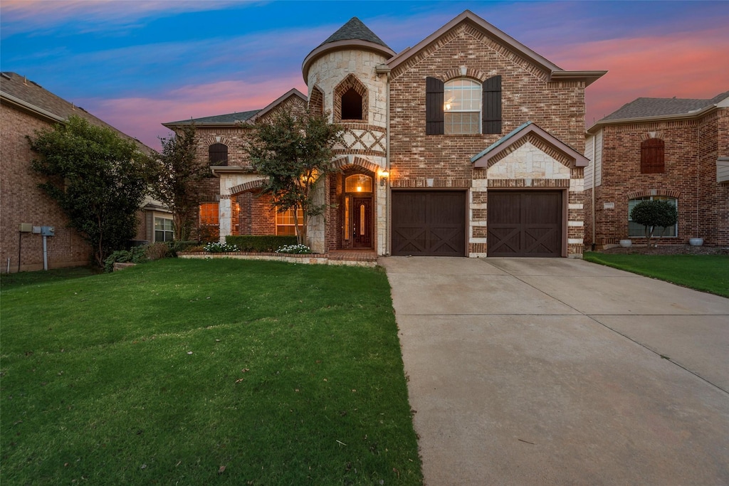 french country style house featuring a garage and a lawn