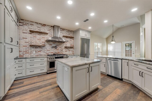 kitchen with white cabinetry, wall chimney exhaust hood, high end appliances, dark wood-type flooring, and pendant lighting