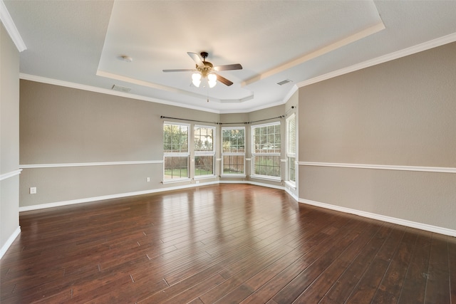 unfurnished room featuring dark hardwood / wood-style floors, a raised ceiling, and ceiling fan